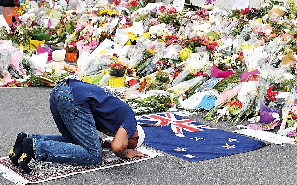 A Muslim worshipper prays at a makeshift memorial at the Al Noor Mosque on Deans Rd in Christchurch, New Zealand. (AAP Image/Mick Tsikas)