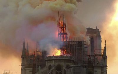Flames and smoke rise as the spire of Notre Dame cathedral is on fire in Paris, Monday, April 15, 2019. (AP Photo/Dominique Bichon)