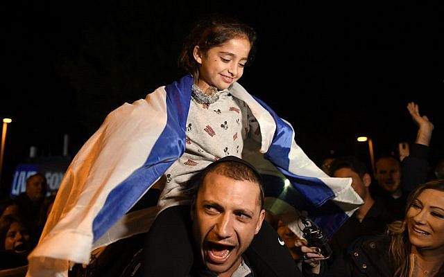 Noya Dahan, 8, rides on the shoulders of her father, Israel Dahan, at a candlelight vigil held for victims of the Chabad of Poway synagogue shooting, Sunday, April 28, 2019, in Poway, Calif. . (AP Photo/Denis Poroy)