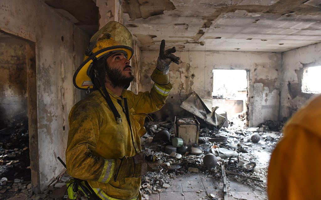 Israeli firefighters check a house that was badly damaged by a fire amidst extreme heat wave in the village of Mevo Modi'im, in central Israel on May 24, 2019.  Photo by: JINIPIX