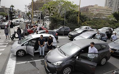 Israelis stand next to their cars as sirens mark a nationwide moment of silence in remembrance of the 6 million Jewish victims of the Holocaust, in Tel Aviv, Thursday, May 2, 2019. (AP Photo/Sebastian Scheiner)
