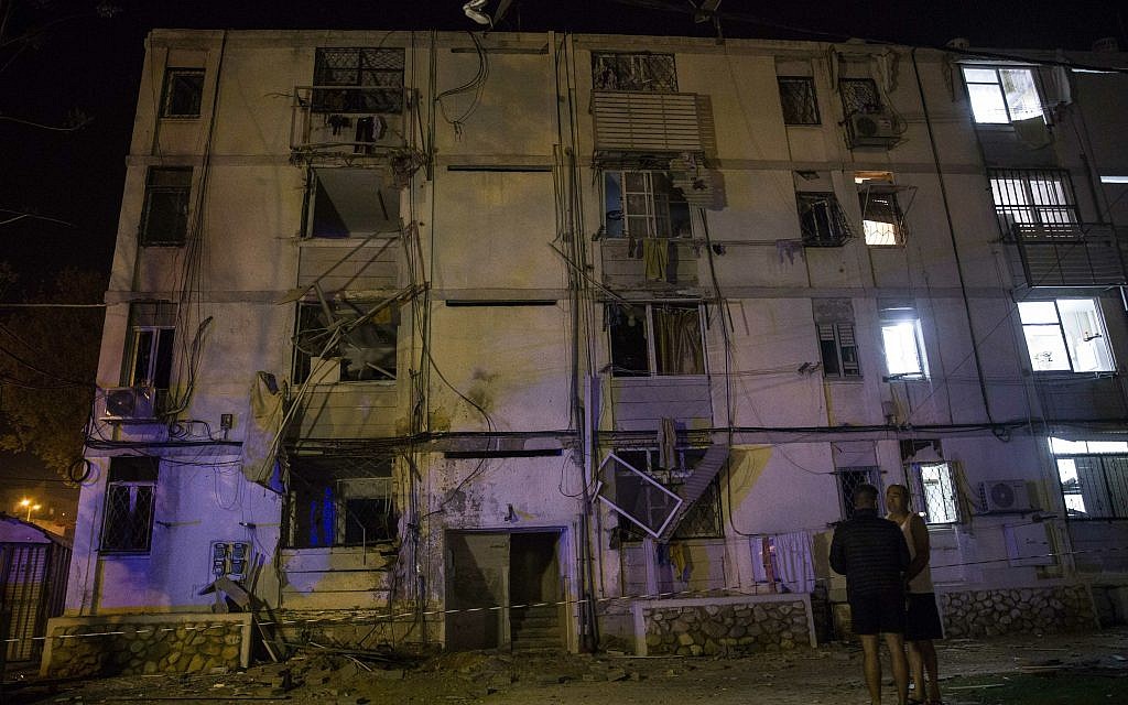 Israelis stand outside their building after it was hit by a rocket fired from Gaza in the costal city of Ashkelon, Israel, Sunday, May 5, 2019.   (AP Photo/Tsafrir Abayov)