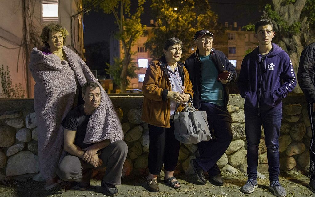 Israelis stand outside their building after it was hit by a rocket fired from Gaza in the costal city of Ashkelon, Israel, Sunday, May 5, 2019. Palestinian terrorists fired over 600 rockets into Israel, drawing dozens of retaliatory airstrikes on targets across the Gaza Strip in a round of intense fighting that broke a month-long lull between the bitter enemies (AP Photo/Tsafrir Abayov)