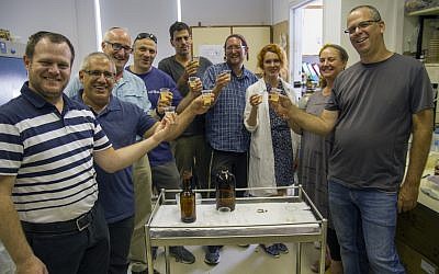 Team of researchers with new-old beer bottles produced in the labs. Photography: Yaniv Berman, courtesy of the Israel Antiquities Authority.