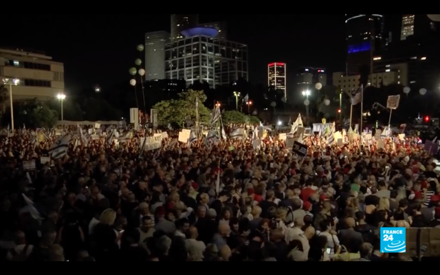 Screenshot from Youtube video from FRANCE 24 English of  thousands in Tel Aviv, protesting against Netanyahu.