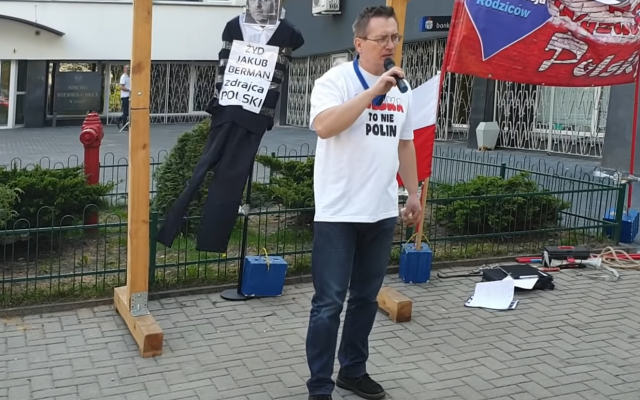 Screenshot from YouTube shows Sławomir Dul in front of the gallows, with Jakub Berman, captioned “Jew”