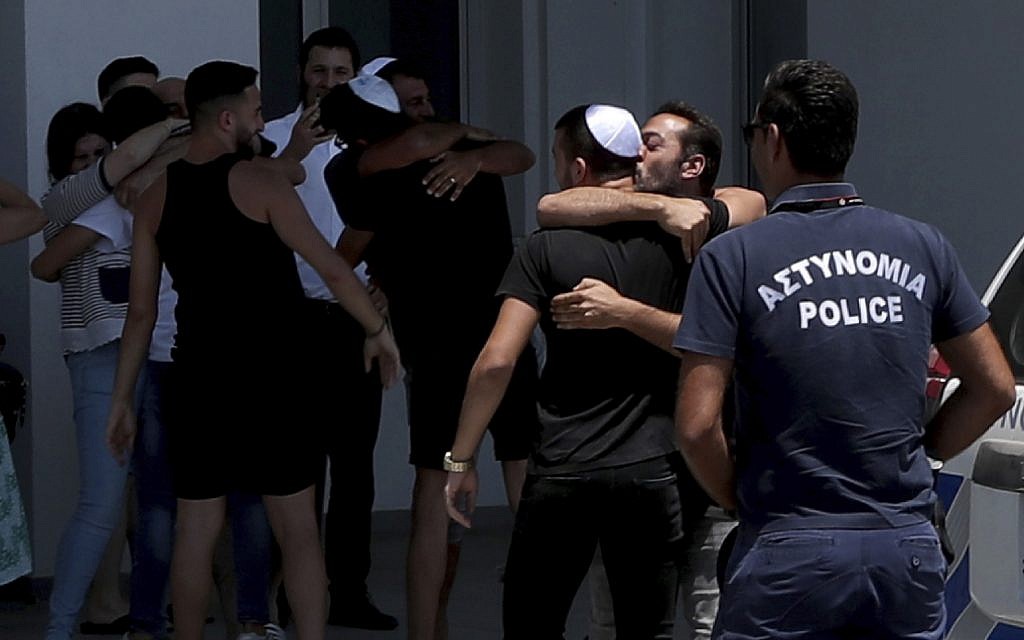 An Israeli teenager is embraced by relatives after being released from Famagusta police headquarters in southeast town of Paralimni, Cyprus, Sunday, July 28, 2019. A lawyer says Cyprus police will release all seven Israeli teenagers who were being detained as suspects in the alleged rape of a 19-year-old British woman. Cypriot Lawyer Yiannis Habaris, who represents two of the seven Israelis, told The Associated Press on Sunday the British woman has been arrested and faces a public nuisance charge. (AP Photo/Petros Karadjias)