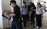 Police officers escort a 19-year-old British woman, second from right, out of Famagusta court in town of Paralimni, Cyprus, Monday, July 29, 2019. . (AP Photo/Petros Karadjias)