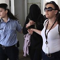Police officers escort a 19-year-old British woman, center, from the Famagusta court in town of Paralimni, Cyprus, Monday, July 29, 2019. She was later cleared of lying about the attack. (AP Photo/Petros Karadjias)