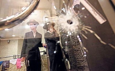 A bullet hole in a glass door of a synagogue that was the scene of a terror attack. Two Palestinians armed with a cleaver and a gun burst in to a shul in the Jerusalem neighbourhood of Har-Nof, killing four Israeli men and wounding several others