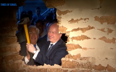 Jason Greenblatt and David Friedman use a sledge hammer to break the wall during the ceremony (screenshot)
