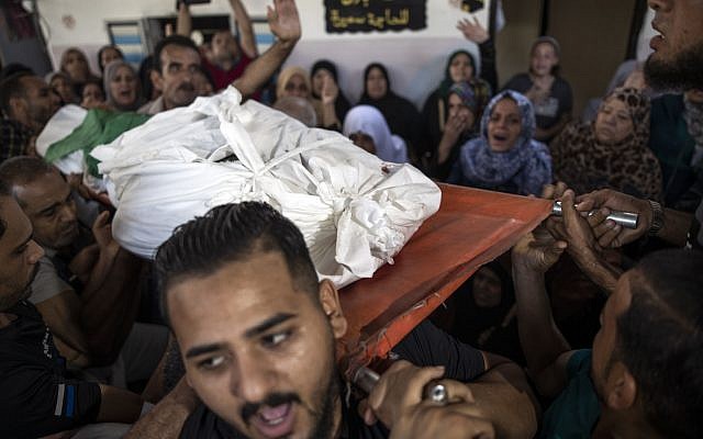 Mourners carry the body of Palestinian Hamas militant, Mohammad Abu Namous, 27, out of the family home during his funeral in the Jabaliya refugee camp, northern Gaza Strip, Sunday, Aug. 18, 2019. (AP Photo/Khalil Hamra)