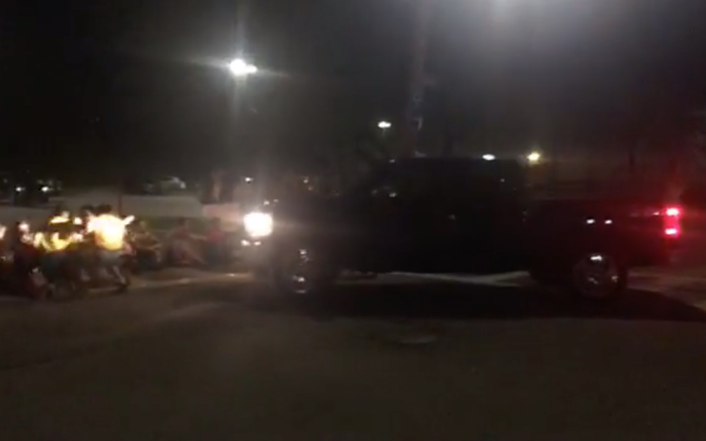 A pickup truck drives into a row of Jewish protesters sitting at the entrance to a parking lot outside an Immigration and Customs Enforcement detention facility in Central Falls, Rhode Island on August 14, 2019. (Screenshot from Facebook VIA JTA)