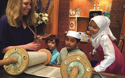Rabbi Miriam Berger shows young members of the Somali Bravanese community a Torah