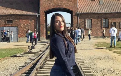 Girl poses for a controversial 'selfie' with the gate of Auschwitz in the background.  (Jewish News)