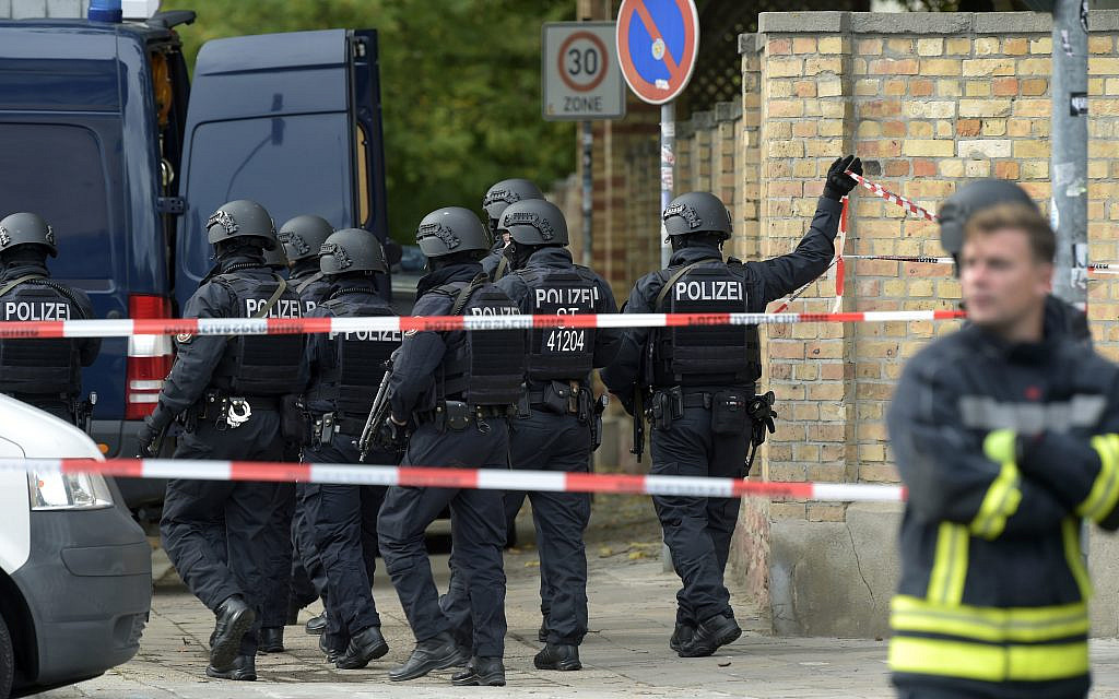 Police officers walk in front of a Jewish cemetery in Halle, Germany, Wednesday, Oct. 9, 2019. One or more gunmen fired several shots on Wednesday in the German city of Halle. Police say a person has been arrested after a shooting that left two people dead. (AP Photo Jens Meyer) Police officers walk in front of a Jewish cemetery in Halle, Germany, Wednesday, Oct. 9, 2019. One or more gunmen fired several shots on Wednesday in the German city of Halle. Police say a person has been arrested after a shooting that left two people dead. (AP Photo Jens Meyer)
