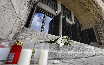 Flowers and candles are set in front of the old synagogue in Essen, Germany, Thursday, Oct. 10, 2019. A heavily armed assailant ranting about Jews tried to force his way into a synagogue in Halle, Germany yesterday, before he killed two people nearby. (AP Photo/Martin Meissner)