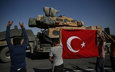 Local residents applaud as a convoy of Turkish forces trucks transporting tanks is driven in Sanliurfa province, southeastern Turkey, at the border with Syria, Saturday, Oct. 12, 2019.  (AP Photo/Lefteris Pitarakis via Jewish News)