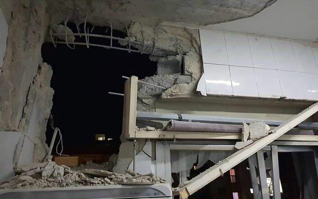 Photo released by the Syrian official news agency SANA, a damaged building targeted by Israeli missile strikes is seen in Qudsaya suburb, western the capital Damascus, Syria, Wednesday, Nov. 20, 2019. (SANA via AP)