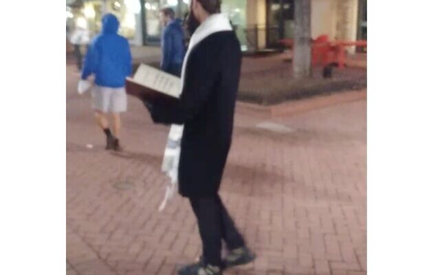 Screenshot from Twitter, showing a man dressed as a Jew, handing out Holocaust denial leaflets