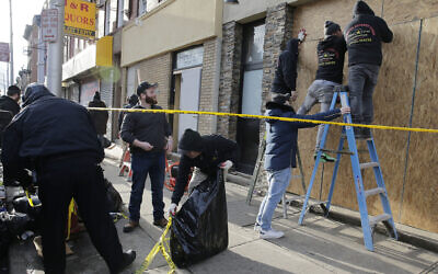 People board up the front of a kosher supermarket thats was the site of a gun battle in Jersey City, N.J., Wednesday, Dec. 11, 2019. The two gunmen in a furious firefight that left multiple people dead in Jersey City clearly targeted the Jewish market, the mayor said Wednesday, amid growing suspicions the bloodshed was an anti-Semitic attack. (AP Photo/Seth Wenig)