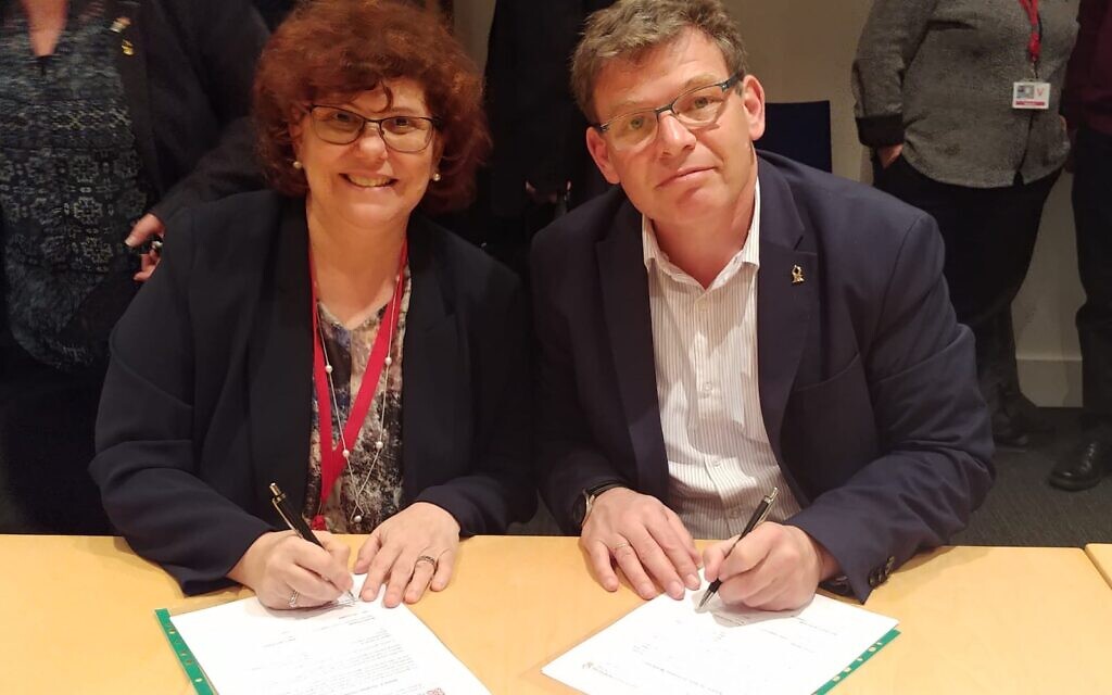 BGU Rector Prof. Chaim Hames (right) and Prof. Dimitra Simeonidou of the University of Bristol sign the MOU on Monday. (Photo Credit: Daphna Frucht/British Embassy Israel)