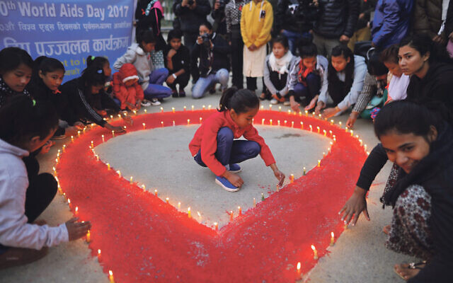 People light candles around the symbol for World Aids Day