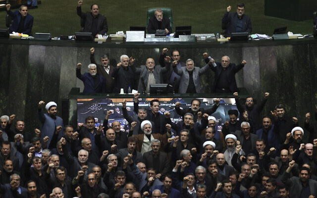Iranian lawmakers chant anti-American and anti-Israeli slogans to protest against the U.S. killing of Iranian top general Qassem Soleimani, at the start of an open session of parliament in Tehran, Iran, Sunday, Jan. 5, 2020.  (Mohammad Hassanzadeh/Tasnim News Agency via AP)