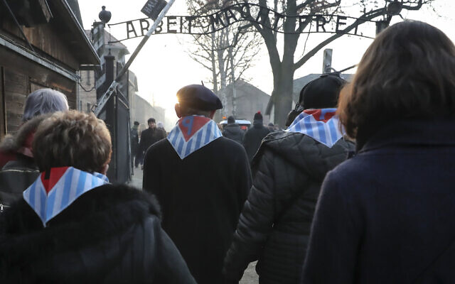 Survivors and their relatives walk through the gates of the Auschwitz Nazi concentration camp to attend the 75th anniversary of its liberation in Oswiecim, Poland, Monday, Jan. 27, 2020. (AP Photo/Czarek Sokolowski)