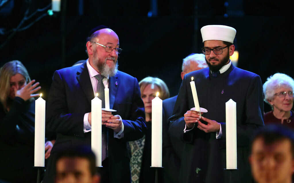 Chief Rabbi Ephraim Mirivis (left) lights a candle during the UK Holocaust Memorial Day Commemorative Ceremony at Central Hall in Westminster, London.  (Photo credit: Chris Jackson/PA Wire)