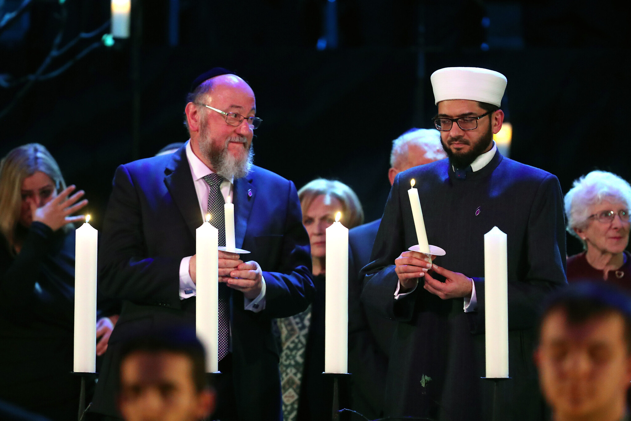 Chief Rabbi Ephraim Mirivis (left) lights a candle during the UK Holocaust Memorial Day Commemorative Ceremony at Central Hall in Westminster, London.  (Photo credit: Chris Jackson/PA Wire)