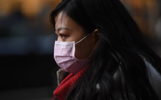 A woman wears a face mask while walking down Kingsway in Holborn, London. PA Photo.: Victoria Jones/PA Wire