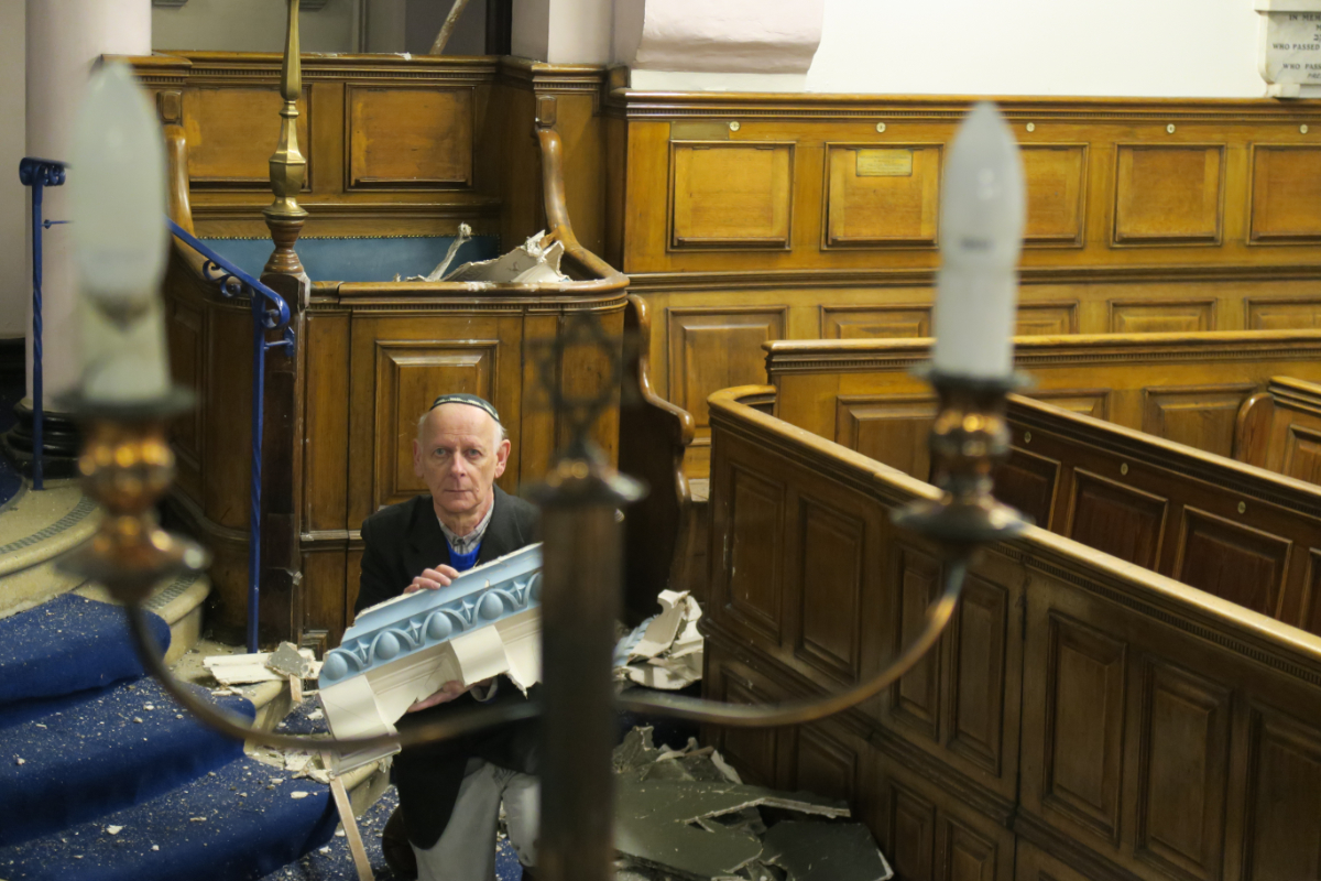 Leon Silver, president of Whitechapel’s East London Synagogue, examines the damage to the historic building. (Credit: Mike Brooke/East London Advertiser)