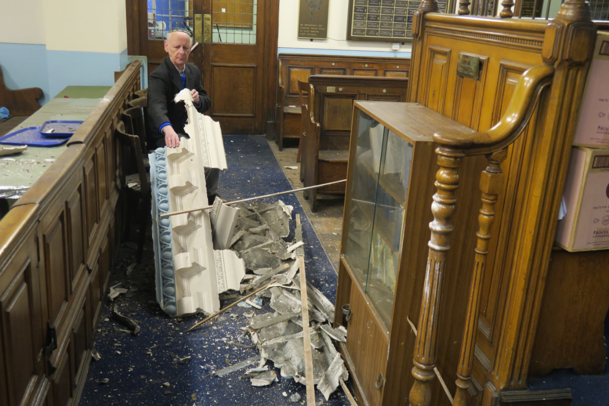 Leon Silver, president of Whitechapel’s East London Synagogue, examines the damage to the historic building. (Credit: Mike Brooke/East London Advertiser)