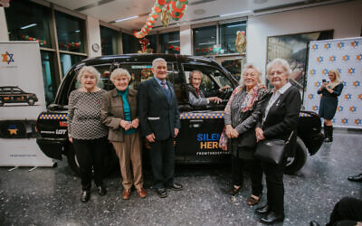 Group of Righteous Among The Nations in front of the Silent Hero taxi being driven by Holocaust Survivor Edward Mosberg (Credit: From the Depths/ Jonny Daniels)