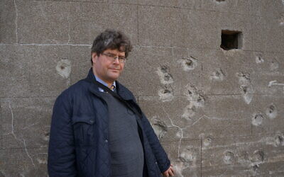 Historian Marcus Roberts standing next to a wall on Alderney believed to be an execution site.