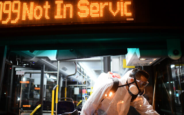 Workers wearing protective suits disinfect a bus as a preventive measure amid fears over the spread of the coronavirus, in Tel Aviv - as public transport is shut down. Photo by: Tomer Neuberg-JINIPIX