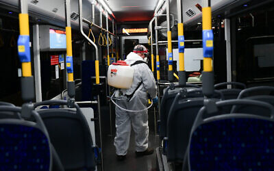 Workers wearing protective suits disinfect a bus as a preventive measure amid fears over the spread of the coronavirus, in Tel Aviv.  Photo by: Tomer Neuberg-JINIPIX