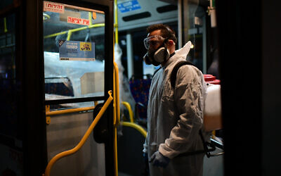 Workers wearing protective suits disinfect a bus as a preventive measure amid fears over the spread of the coronavirus, in Tel Aviv on March 9, 2020,  (Photo by: Tomer Neuberg-JINIPIX)