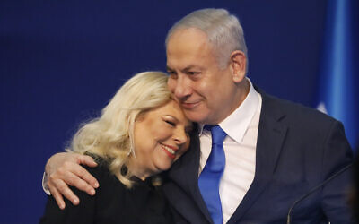 Israeli Prime Minister Benjamin Netanyahu hugs his wife Sara after first exit poll results for the Israeli elections at his party's headquarters in Tel Aviv, Israel, Monday, Feb. 2, 2020. (AP Photo/Ariel Schalit)