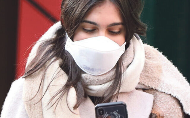A pedestrian in London wears a protective face mask