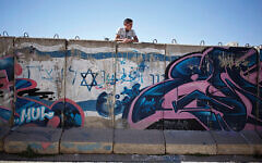 A Palestinian boy looks behind a wall separating Jewish part and Palestinian part of the West Bank. (AP Photo/Ariel Schalit) A Palestinian boy looks behind a wall separating Jewish part and Palestinian part of the West Bank. (AP Photo/Ariel Schalit)