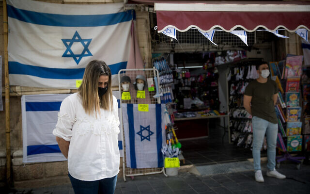 Israelis wearing protective masks due to the COVID-19 pandemic stand in silence in Jerusalem on April 21, 2020 as sirens wail across Israel for two minutes marking the annual day of remembrance for the six million Jewish victims of the Nazi genocide.  Photo by: JINIPIX