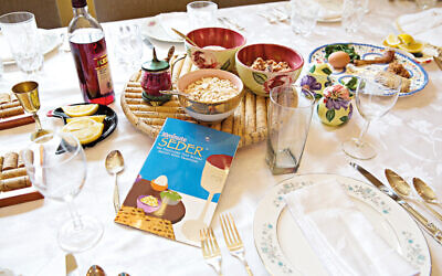 Passover Seder plate and Haggadah on traditionally set table with several side dishes