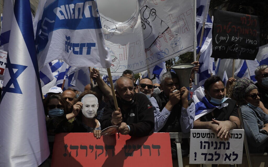 Israeli right wing activists hold flags outside the Jerusalem district court in Jerusalem, Sunday, May 24, 2020. (AP Photo/Sebastian Scheiner) Israeli right wing activists hold flags outside the Jerusalem district court in Jerusalem, Sunday, May 24, 2020. (AP Photo/Sebastian Scheiner)