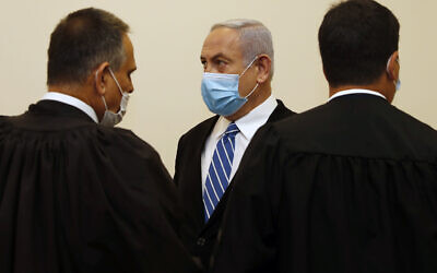 Israeli Prime Minister Benjamin Netanyahu, center, wearing a face mask in line with public health restrictions due to the coronavirus pandemic . (Ronen Zvulun/ Pool Photo via AP)