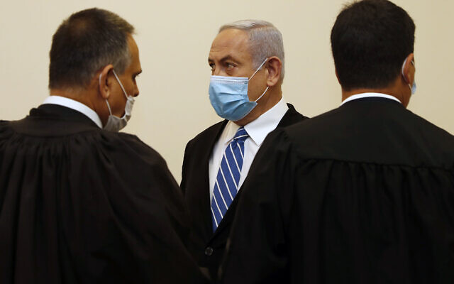 Israeli Prime Minister Benjamin Netanyahu, center, wearing a face mask in line with public health restrictions due to the coronavirus pandemic . (Ronen Zvulun/ Pool Photo via AP)