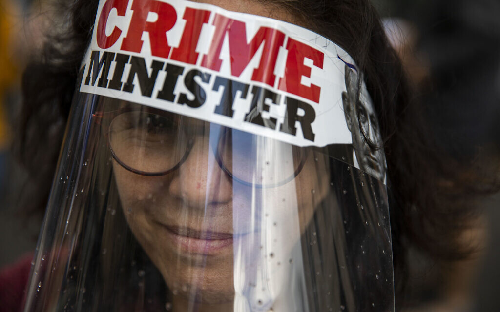 A protester against Israel's Prime Minister Benjamin Netanyahu wears a face mask during a protest outside his residence in Jerusalem, Sunday, May 24, 2020. . (AP Photo/Ariel Schalit) A protester against Israel's Prime Minister Benjamin Netanyahu wears a face mask during a protest outside his residence in Jerusalem, Sunday, May 24, 2020. . (AP Photo/Ariel Schalit)