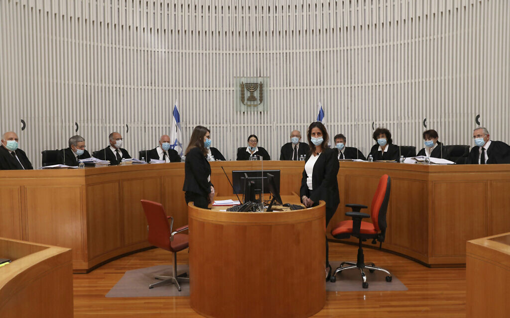 A panel of 11 Israeli Supreme Court judges wearing face masks hear arguments against the legality of Prime Minister Benjamin NetanyahuÕs coalition deal with his former rival, Benny Gantz, at the Israeli Supreme Court in Jerusalem, Monday, May 4, 2020. (Abir Sultan/Pool via AP)