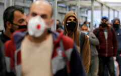 Palestinian laborers head to work in Israel through a checkpoint amid concerns about the spread of the coronavirus disease (COVID-19), near Hebron in the West Bank May 3, 2020. REUTERS/Mussa Qawasma Palestinian laborers head to work in Israel through a checkpoint amid concerns about the spread of the coronavirus disease (COVID-19), near Hebron in the West Bank May 3, 2020. REUTERS/Mussa Qawasma